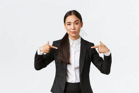 身穿黑色西装的有自信笑容女销售员展示了拇指保证产品质量或提供了最佳服务销售经理试图向客户出售某件东西白自信的笑脸女销售员展示